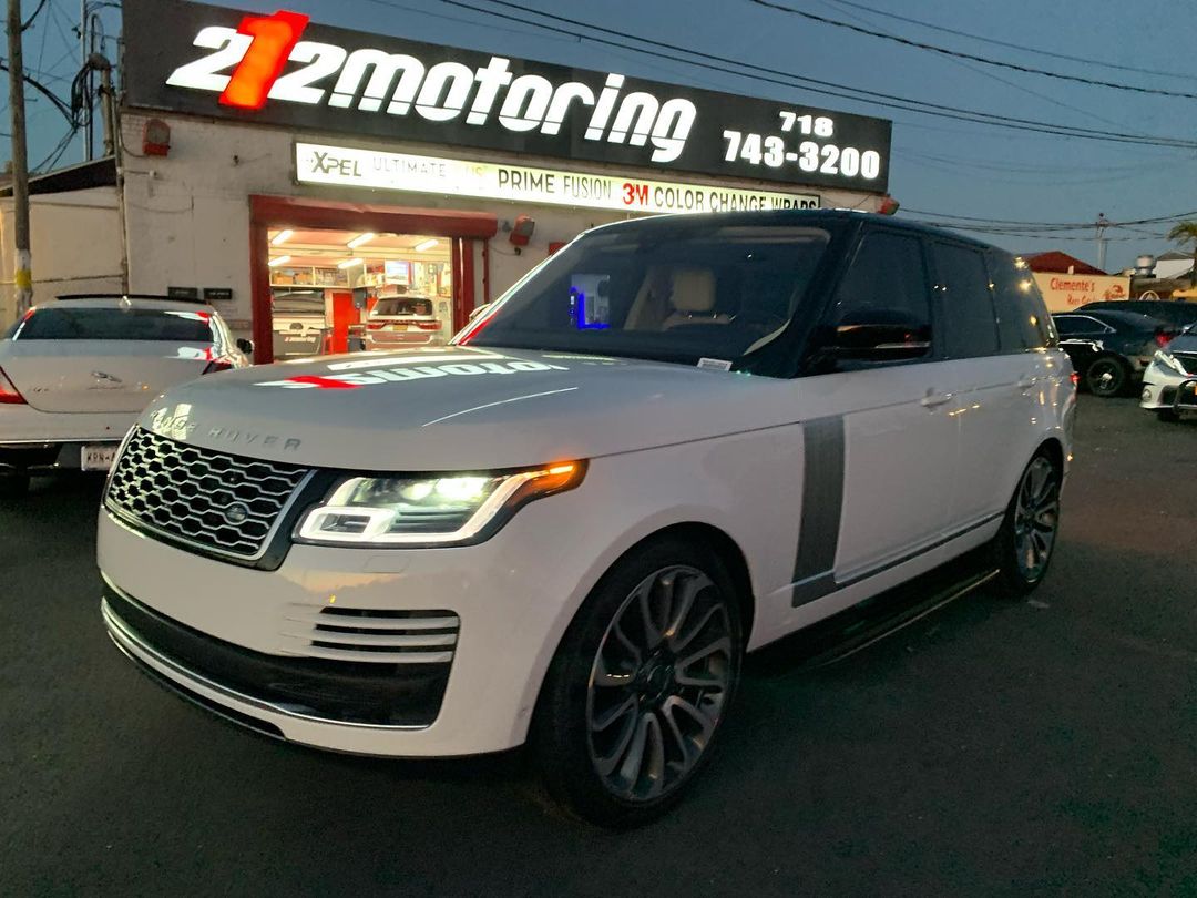 A white range rover in front of 212 Motoring