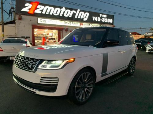 A white range rover in front of 212 Motoring