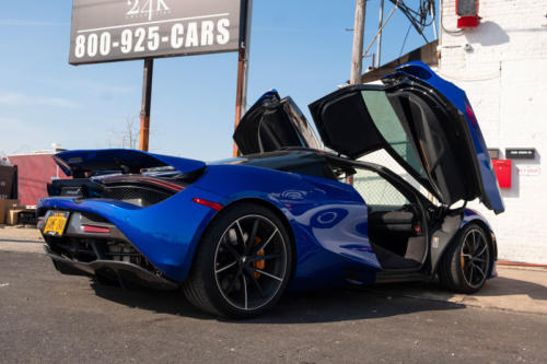 A blue car with open gull-wing doors